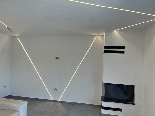 Geometrijski V-uzorak LED profila na zidu dnevnog boravka